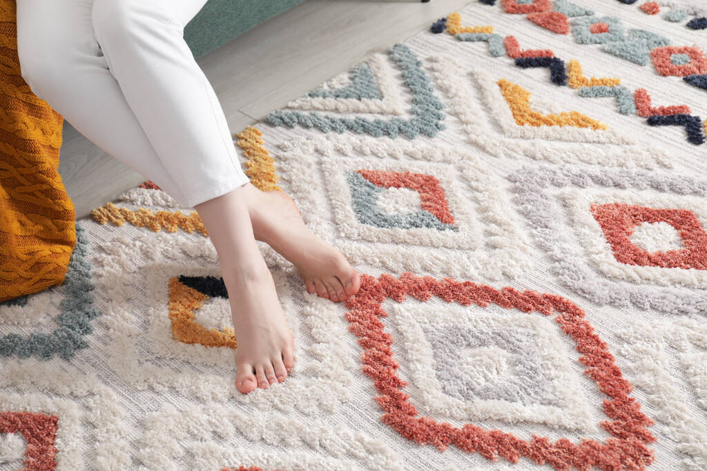 Mujer en alfombra con patrón en casa, primer plano. Espacio para texto - Foto, Imagen