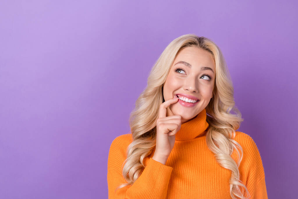 Zdjęcie optymistycznej seksownej dziewczyny ze stylową fryzurą ubrany pomarańczowy sweter wygląd puste miejsca palec zęby izolowane na fioletowym tle kolor. - Zdjęcie, obraz