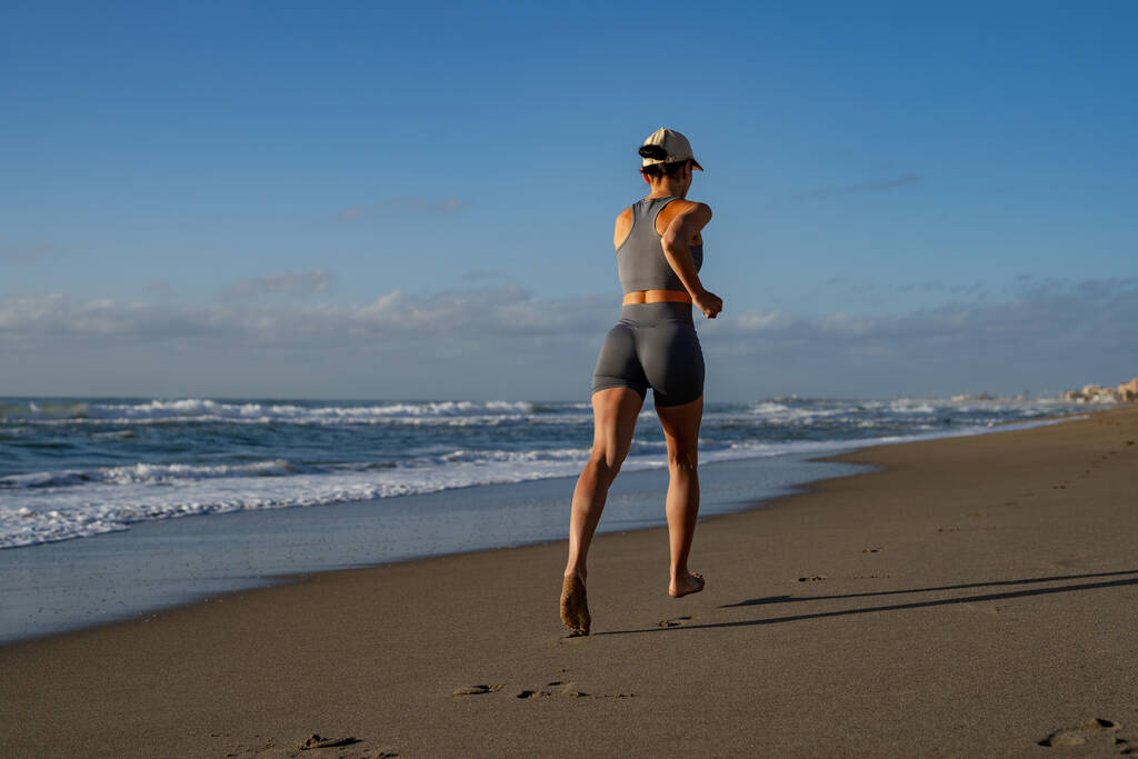 belle jeune fille est engagée dans le jogging sur le bord de mer arrière  - Photo, image