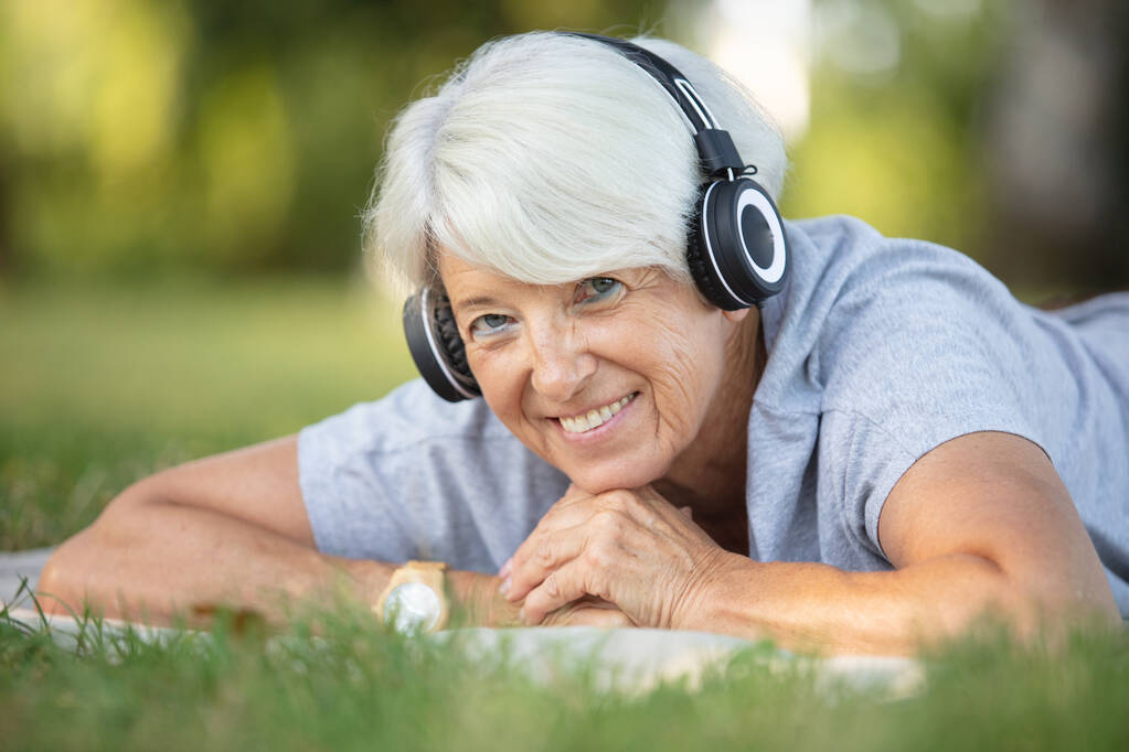 Porträt einer glücklichen Seniorin mit Kopfhörern - Foto, Bild