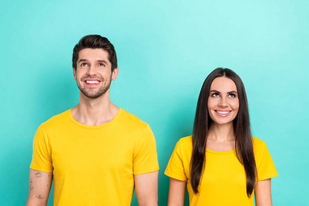 Foto di denti bianchi sorridenti modelli positivi giovane coppia soddisfatto indossare giallo t-shirt cercando mockup nuovo evento isolato su sfondo di colore ciano. - Foto, immagini