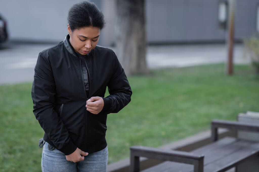 Young multiracial woman wearing black jacket on urban street  - Photo, Image