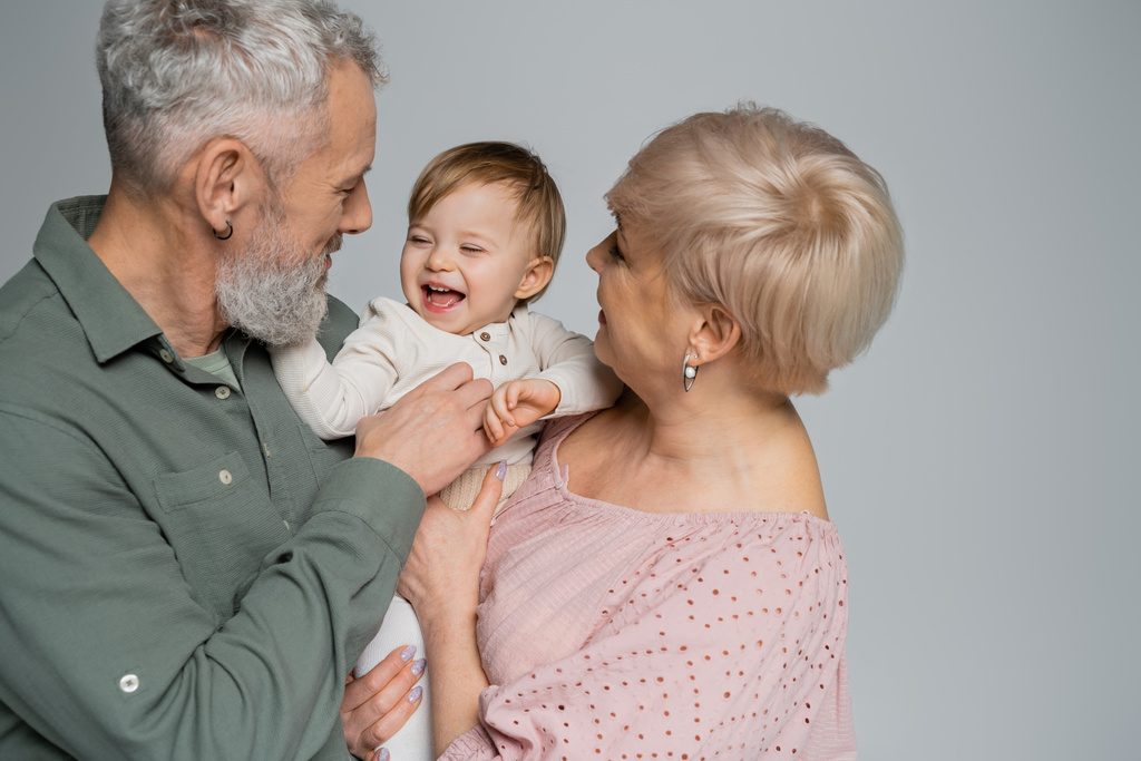 щасливі бабусі і дідусі сміються дівчинка ізольовані на сірому
 - Фото, зображення