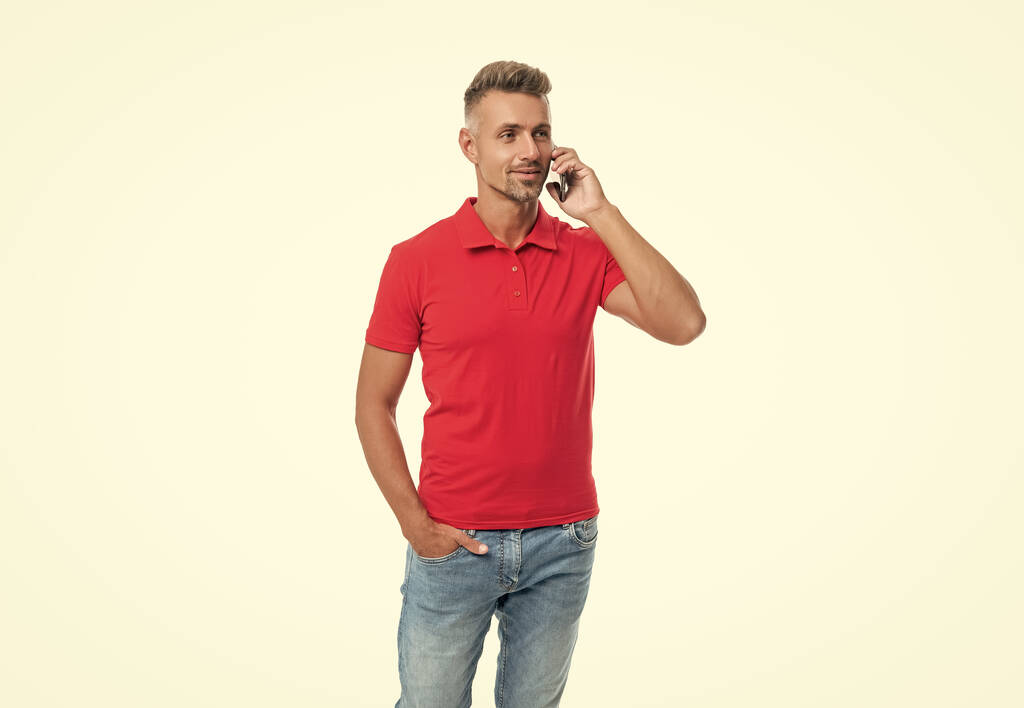 man in red tshirt speaking on cell phone isolated on white background. - Foto, afbeelding