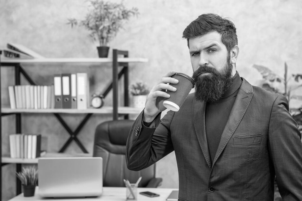 зрелый предприниматель в куртке, кофе-брейк с чашкой в офисе, вынос. - Фото, изображение