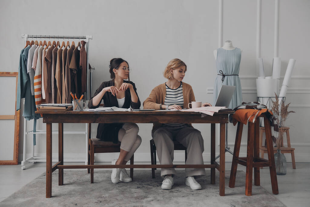 Dos diseñadoras de moda trabajando juntas en una nueva colección en el taller - Foto, Imagen