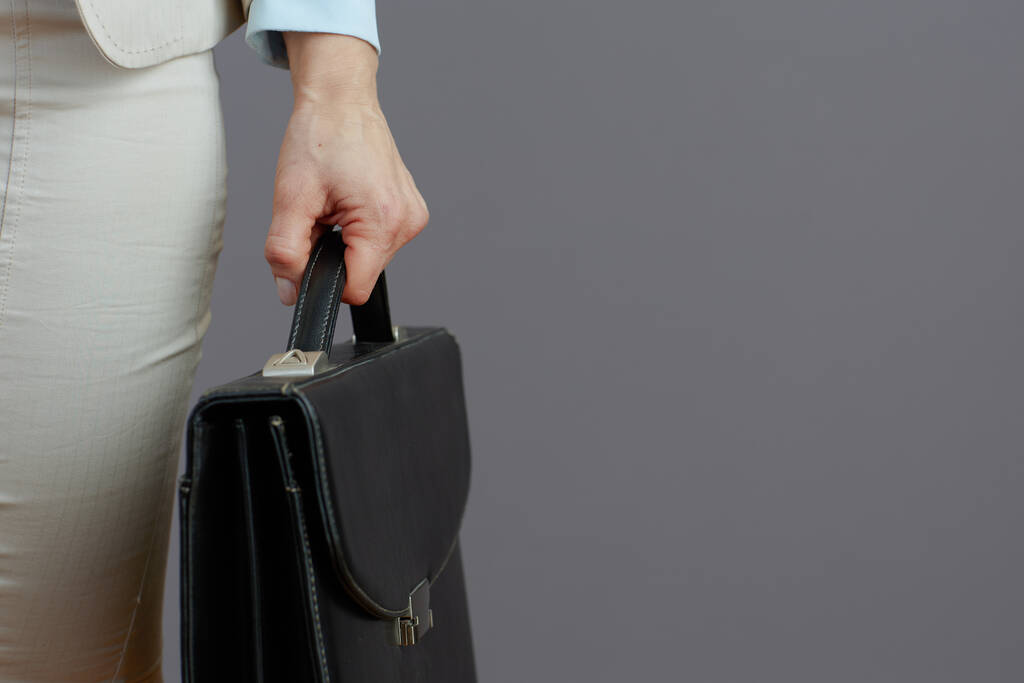 Крупним планом на жінку-працівника з портфелем на сірому фоні
. - Фото, зображення