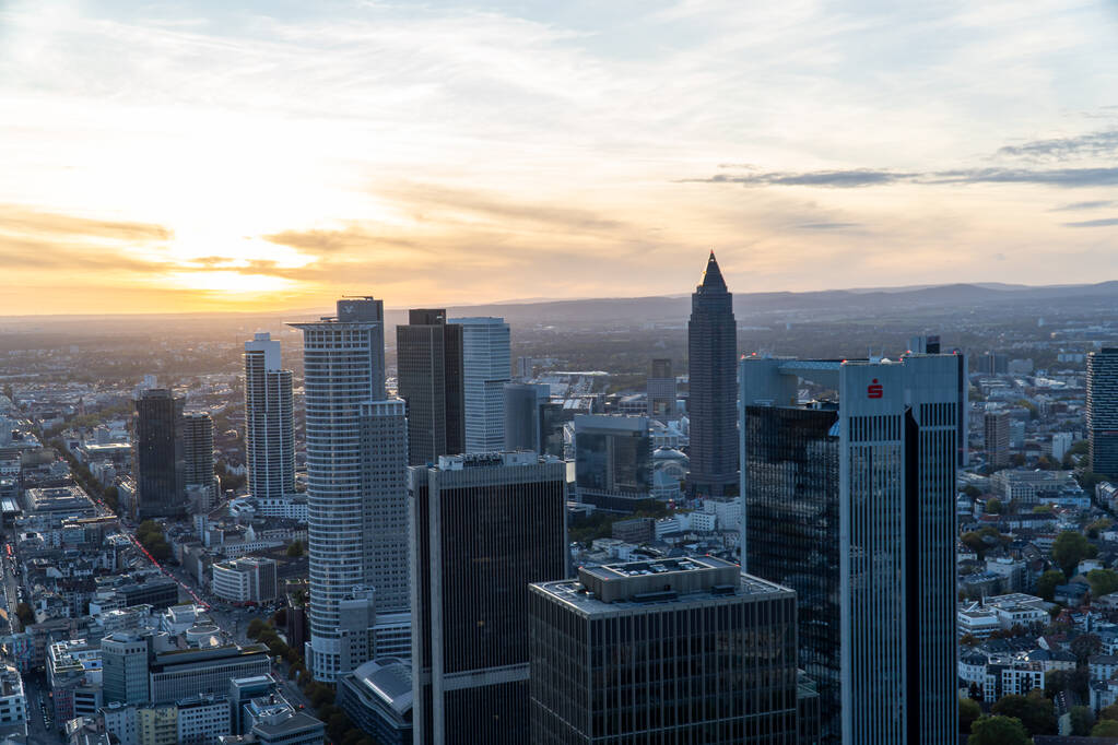 Luftaufnahme der Frankfurter Skyline bei Sonnenuntergang. Modernes Gebäude, das das letzte Sonnenlicht des Tages widerspiegelt. - Foto, Bild