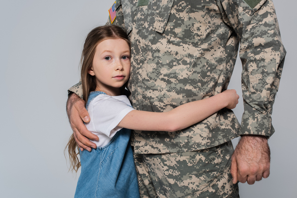 Frühchen umarmt tapferen Vater in Uniform während Gedenktag isoliert auf grau  - Foto, Bild