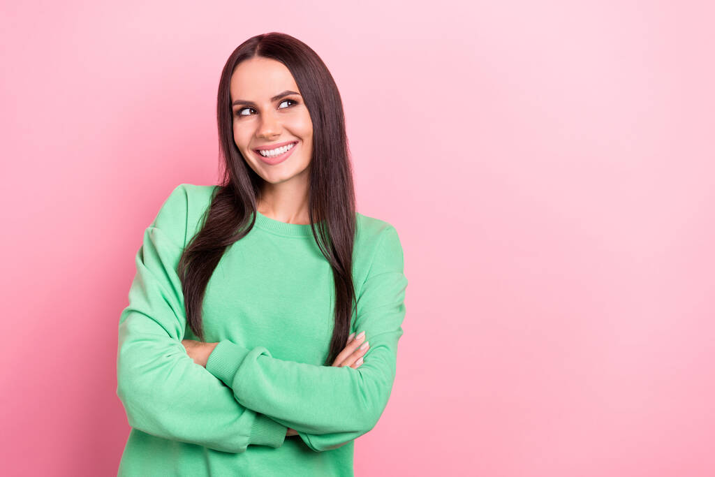 Фотографія посмішки оптимістична дама схрещених рук носить зелену сорочку, виглядає вдумливо порожній простір гарна реклама, ізольована на рожевому кольоровому фоні
. - Фото, зображення