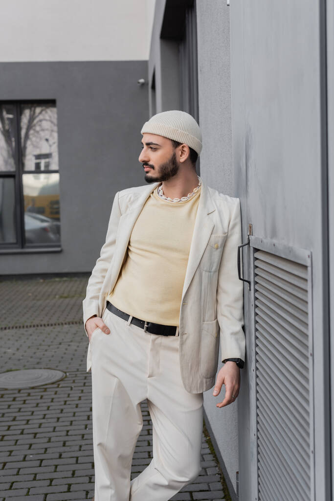Well dressed gay man in beige jacket posing near building outdoors  - Photo, Image