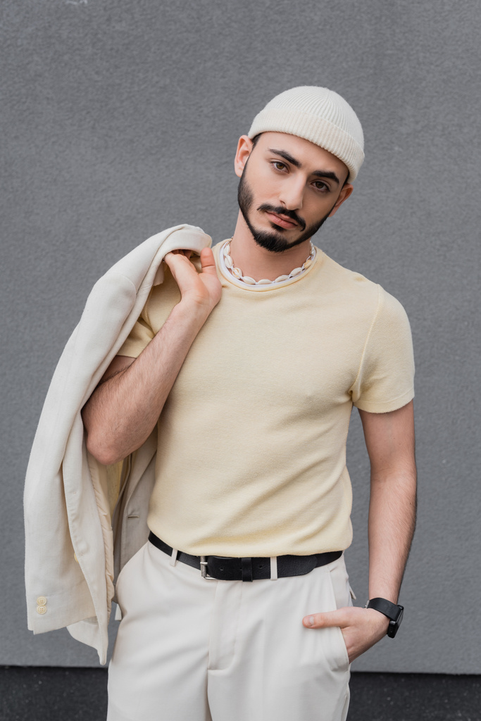 Ritratto di uomo gay alla moda in cappello tenuta giacca e posa all'aperto  - Foto, immagini