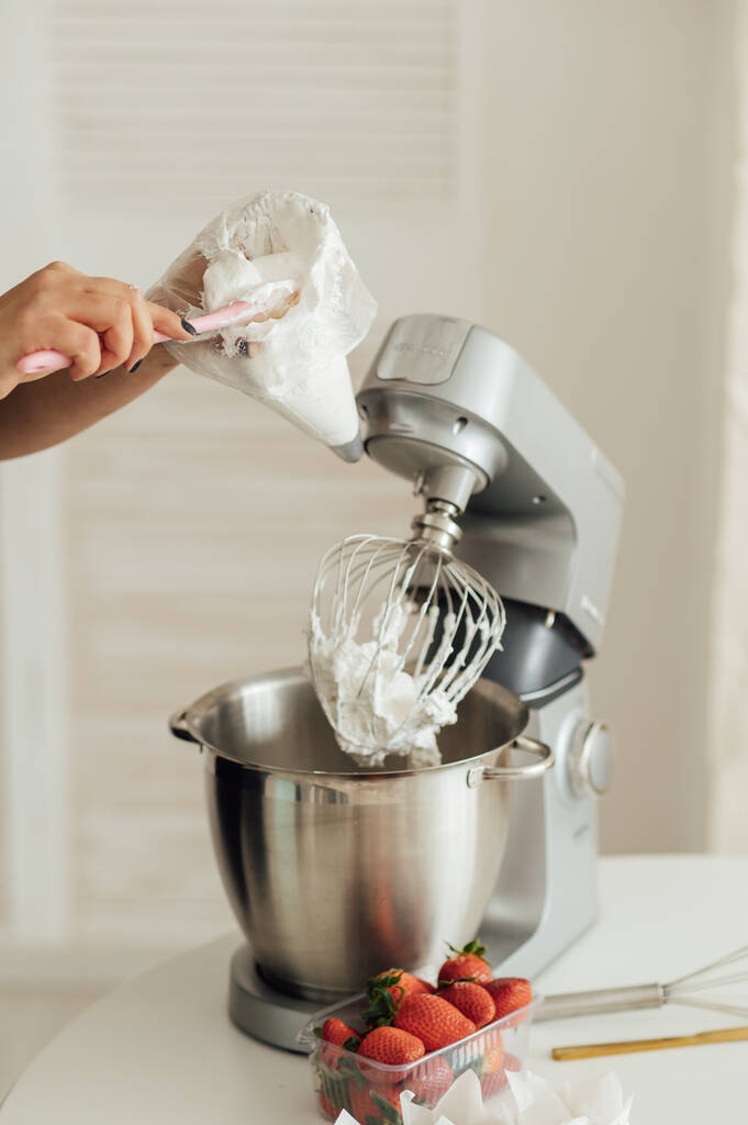 Dívka kuchařka vloží krém z mixéru do formy pro zdobení dortů. - Fotografie, Obrázek