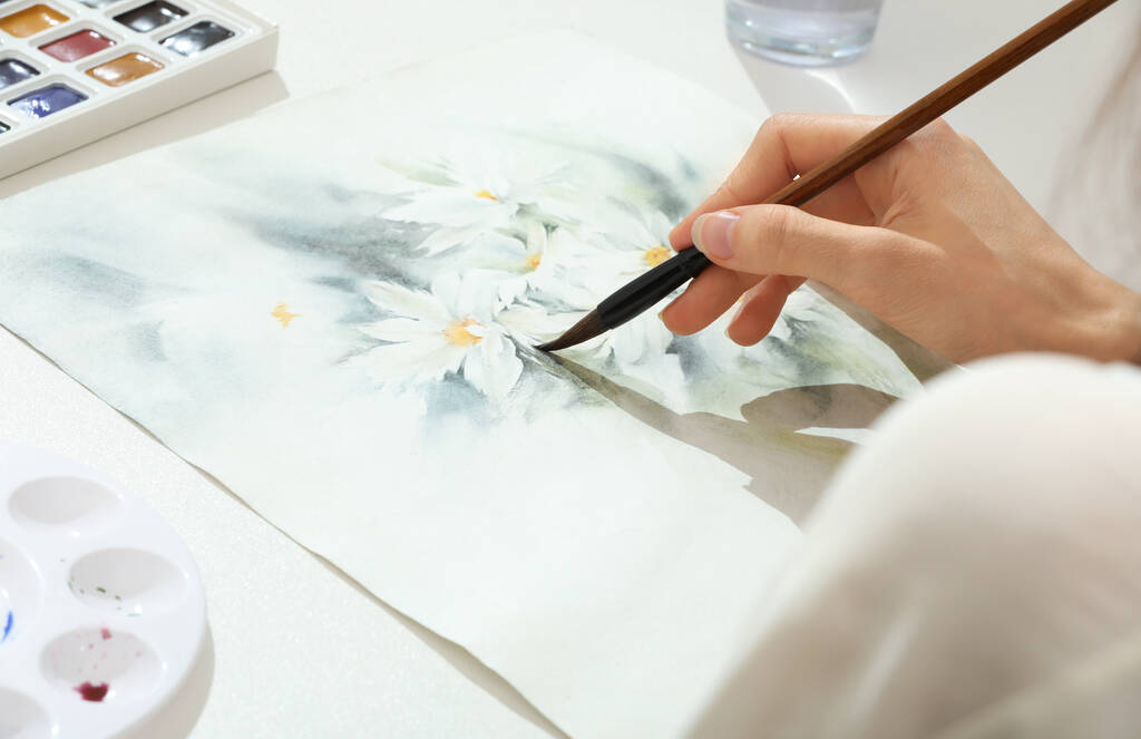 Frau bemalt Blumen mit Aquarell an weißem Tisch, Nahaufnahme. Kreative Kunstwerke - Foto, Bild