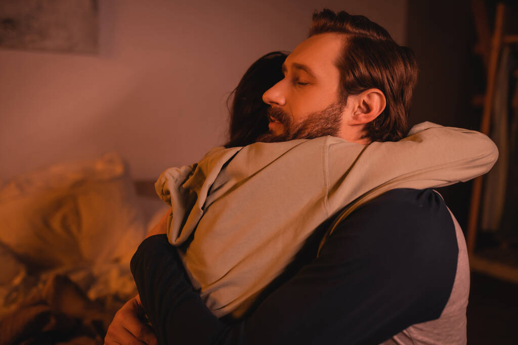 gondoskodó férfi átölel és megnyugtat barátnő otthon este  - Fotó, kép
