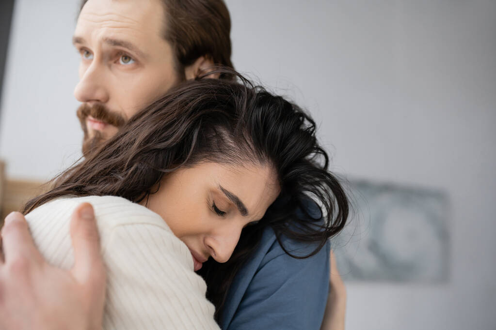 Caring man hugging and consoling sad brunette girlfriend at home  - Photo, Image