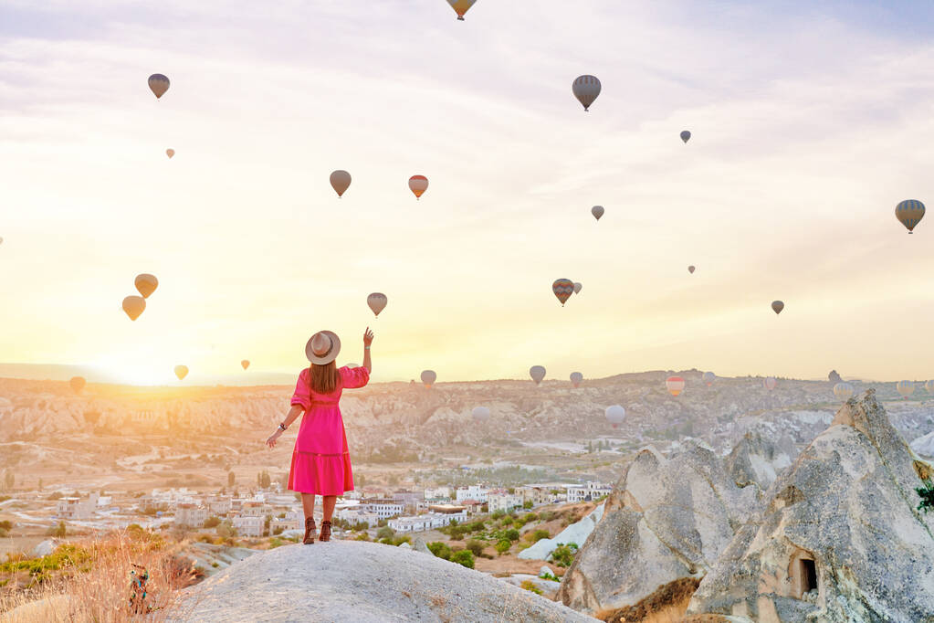 Beztroski szczęśliwy inspirowane dziewczyna podróżnik spaceru w dolinie w Anatolii, Kapadokya. Dotykanie latające balony w pięknym miejscu w Nevsehir, Goreme - Zdjęcie, obraz