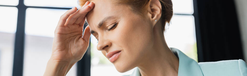 mujer de negocios cansada con los ojos cerrados sosteniendo la mano cerca de la frente y sufriendo de dolor de cabeza en la oficina, pancarta - Foto, Imagen