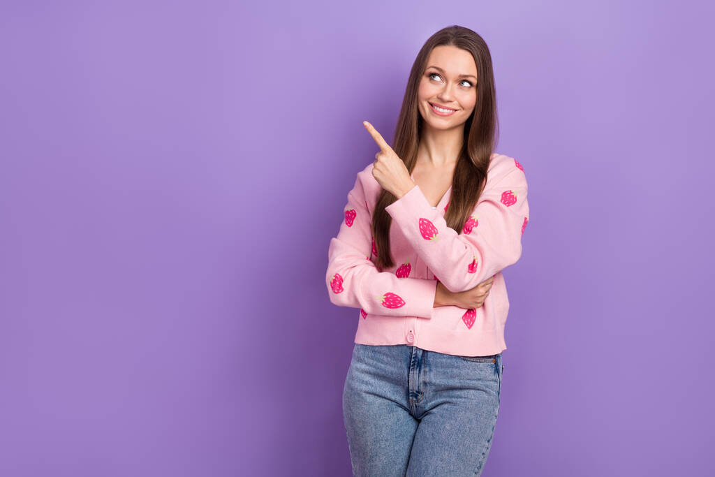 Фото молодої милої жінки рожевий светр полуничний орнамент прямий палець виглядає порожнім простором новий банер кафетерії ізольований на фіолетовому кольоровому фоні
. - Фото, зображення