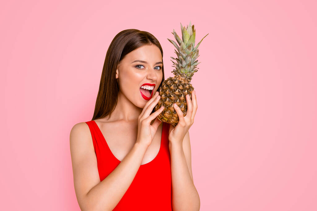 Travel trip tourism resort lifestyle emotion expressing concept. Photo portrait of excited attractive stunning gorgeous showing teeth lady trying to bite ananas in palms isolated on vivid background. - Photo, Image