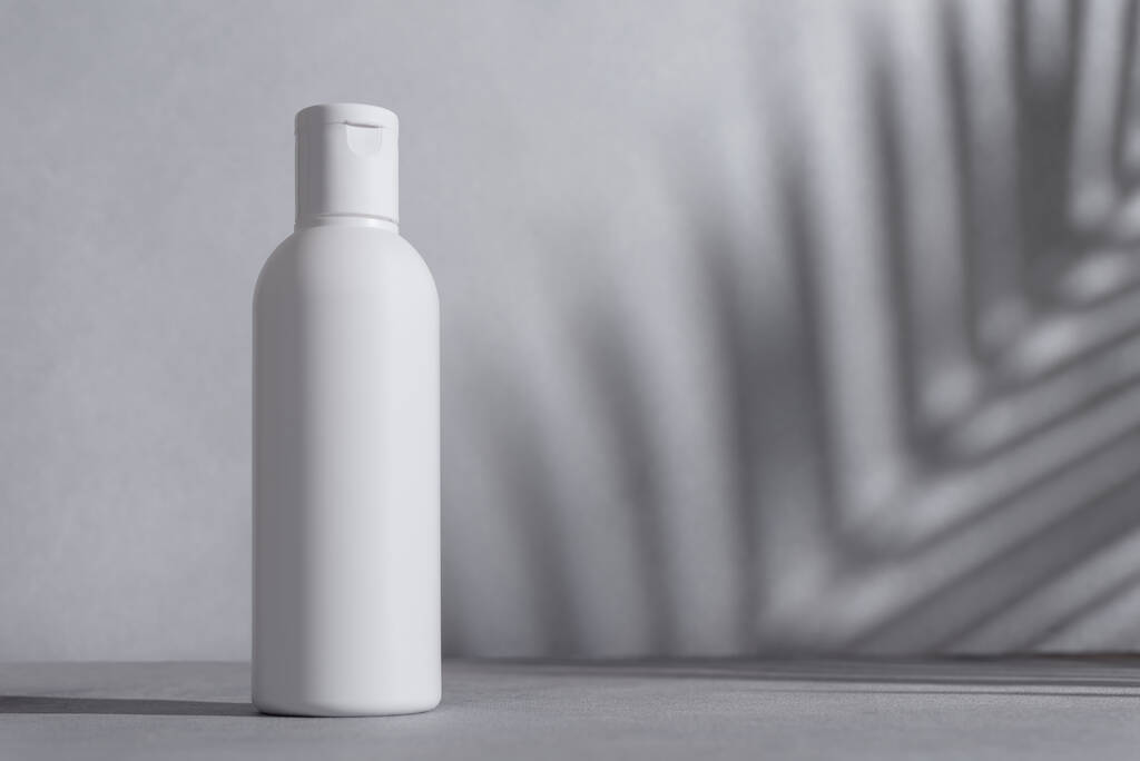 Natürliche Bio-Kosmetikflasche mit weißen Palmblättern. Spa- und Wellness-Konzept. - Foto, Bild