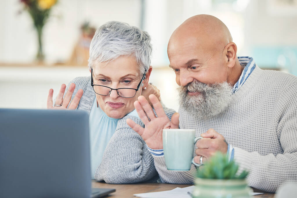 Ordenador portátil, pareja de ancianos y ola en videollamada con café en casa, hablando y hablando en casa. Ordenador, jubilación y hombre y mujer saludando en el chat virtual, saludo en línea y feliz. - Foto, imagen