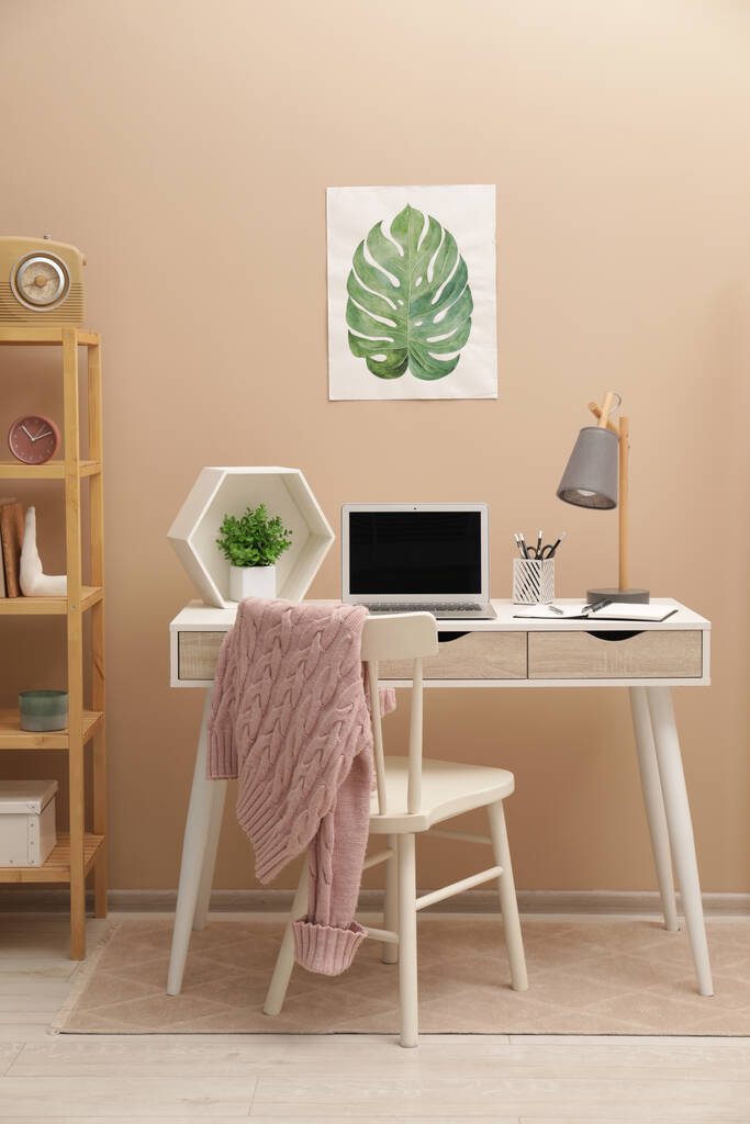 机の上にモダンなラップトップと快適な椅子と居心地の良い職場自宅 - 写真・画像