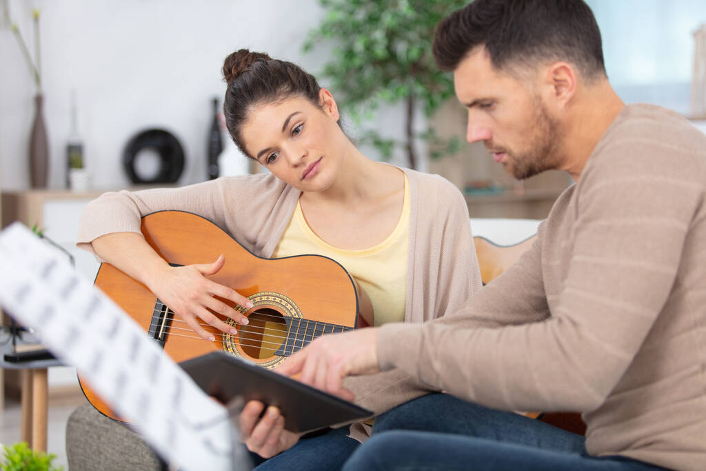 mężczyzna muzyk uczy kobieta student jak grać na gitarze - Zdjęcie, obraz