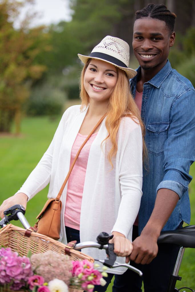 szczęśliwa para zabawy podczas jazdy na rowerze po wiejskiej drodze - Zdjęcie, obraz