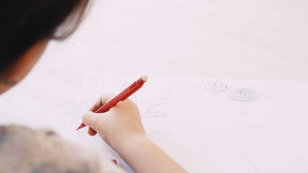 Kreatív kép. Gyerekfestés. Művészeti hobbi. Felismerhetetlen gyermek rajz fehér papírra ceruzával ülő asztal elmosódott. - Fotó, kép