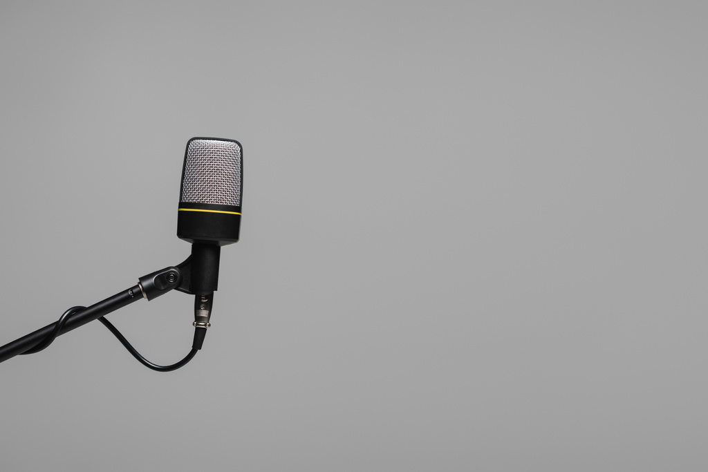 Μικρόφωνο με σύρμα σε black metal stand μονωμένο σε γκρι χρώμα με copy space, φωτογραφία στούντιο  - Φωτογραφία, εικόνα
