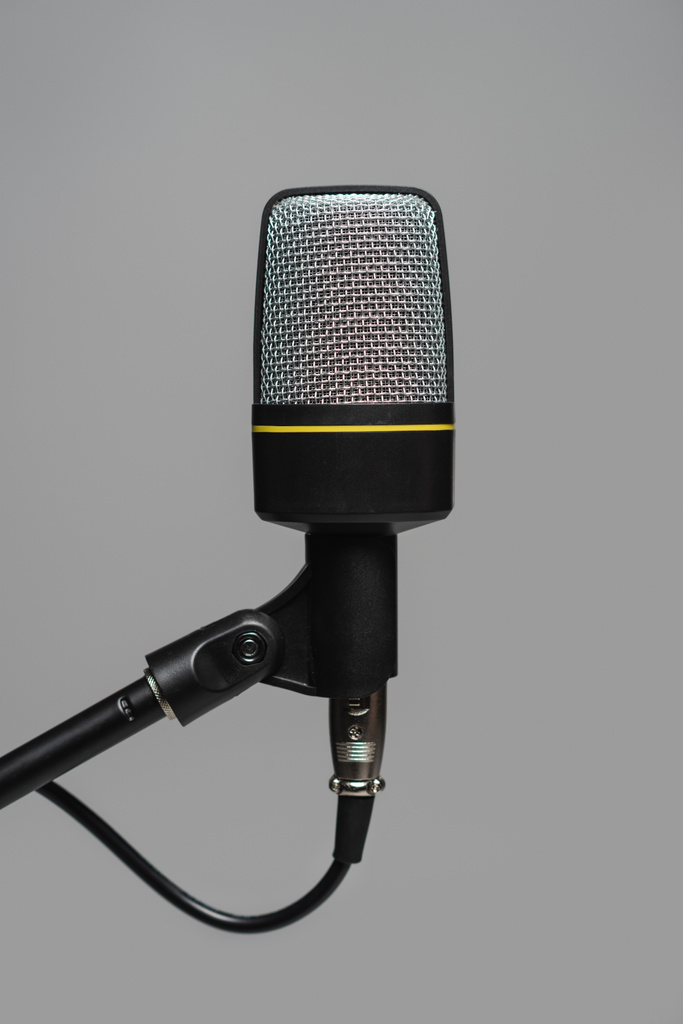 Közelkép a mikrofon fekete drót fém állvány elszigetelt szürke, stúdió fotó  - Fotó, kép