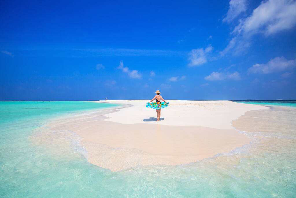 Mujer joven en la playa tropical de arena blanca rodeada de aguas turquesas del océano de Maldivas - Foto, imagen