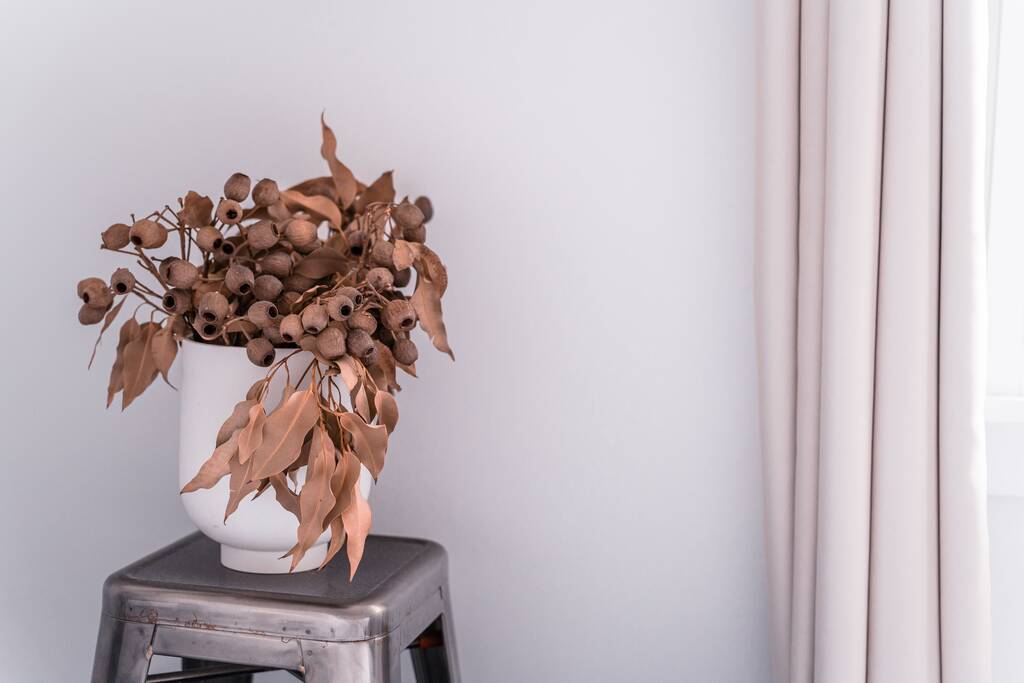 A vista de um vaso decorativo marrom ramos de plantas de Gumtree em um quarto - Foto, Imagem
