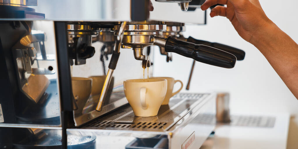 Крупним планом бариста готує замовлення клієнтів, роблячи чашку кави з кавовою еспресо-машиною. Виготовлення еспресо, американо. Малий кавовий бізнес
 - Фото, зображення
