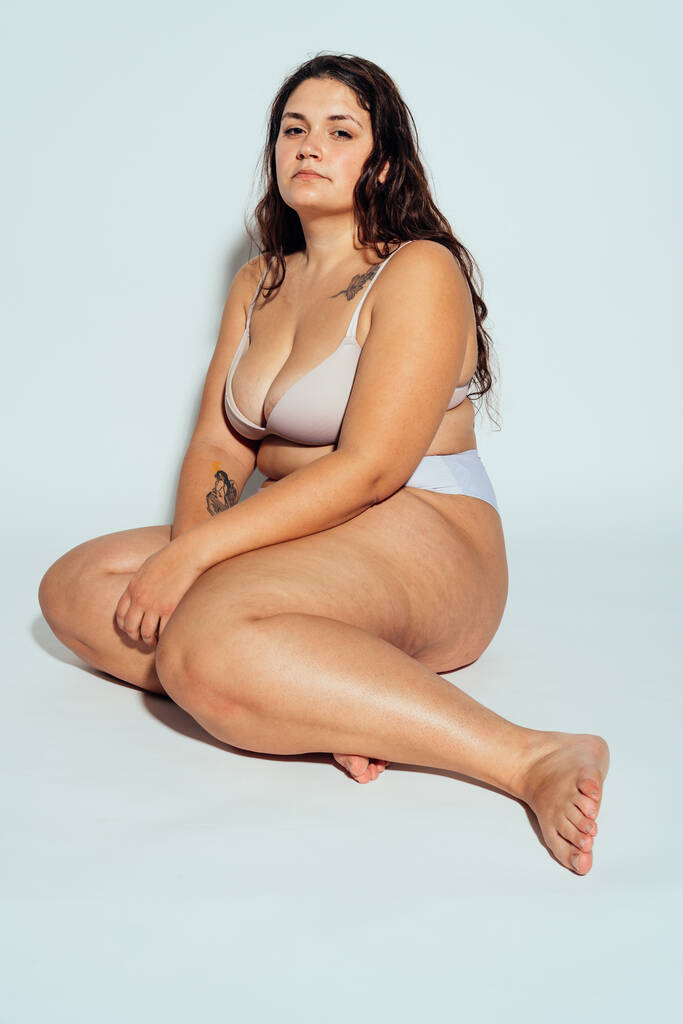Plus Size Frau posiert im Studio in Dessous. Modell auf weißem Hintergrund. Hartes Licht Studio gedreht - Foto, Bild