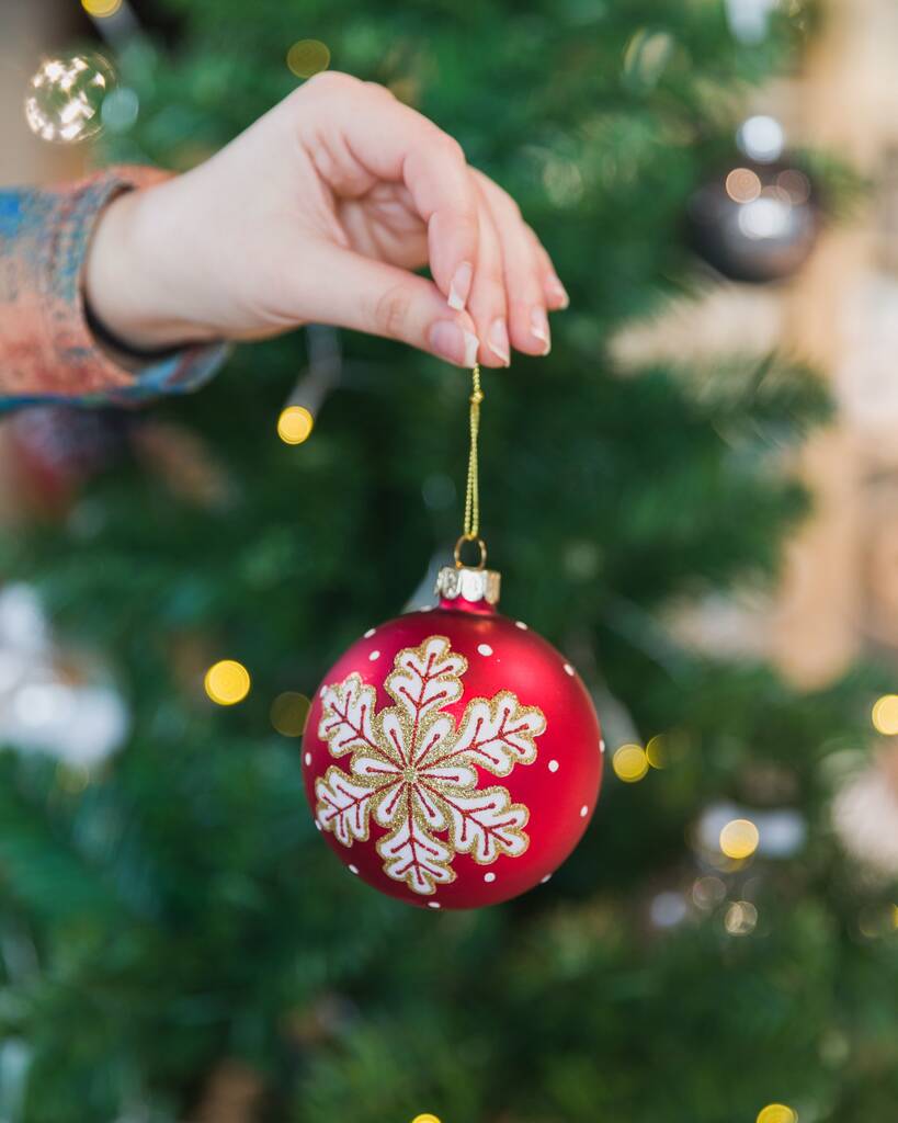 Un selettivo di decorazioni di un albero di Natale in una mano - Foto, immagini