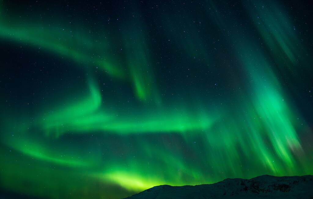 Красивый снимок ярко-зеленого ауры и северного сияния над горами в Норвегии - Фото, изображение