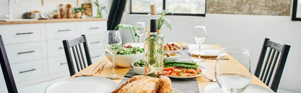 bouteille et verres à vin près de poulet frit et légumes servis sur la table dans la cuisine moderne, bannière  - Photo, image