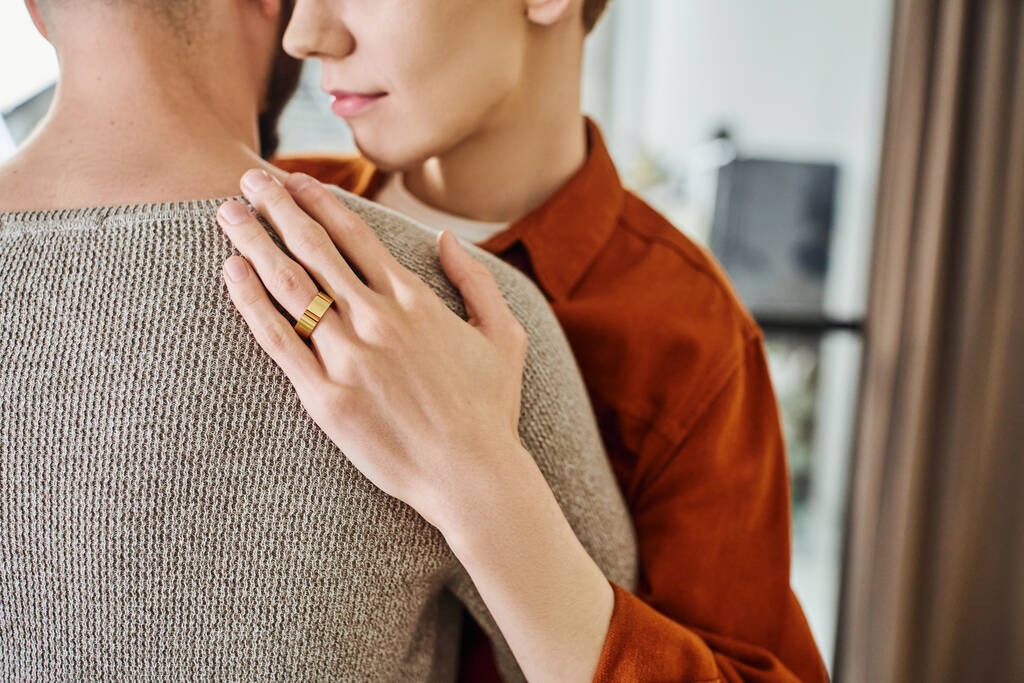 částečný pohled na homosexuála ve snubním prstenu objímajícího partnera doma - Fotografie, Obrázek