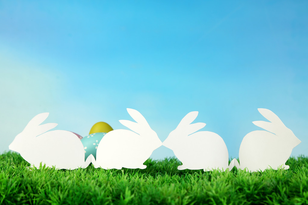 Papier Pasen konijnen en eieren op groen gras, op hemelachtergrond - Foto, afbeelding