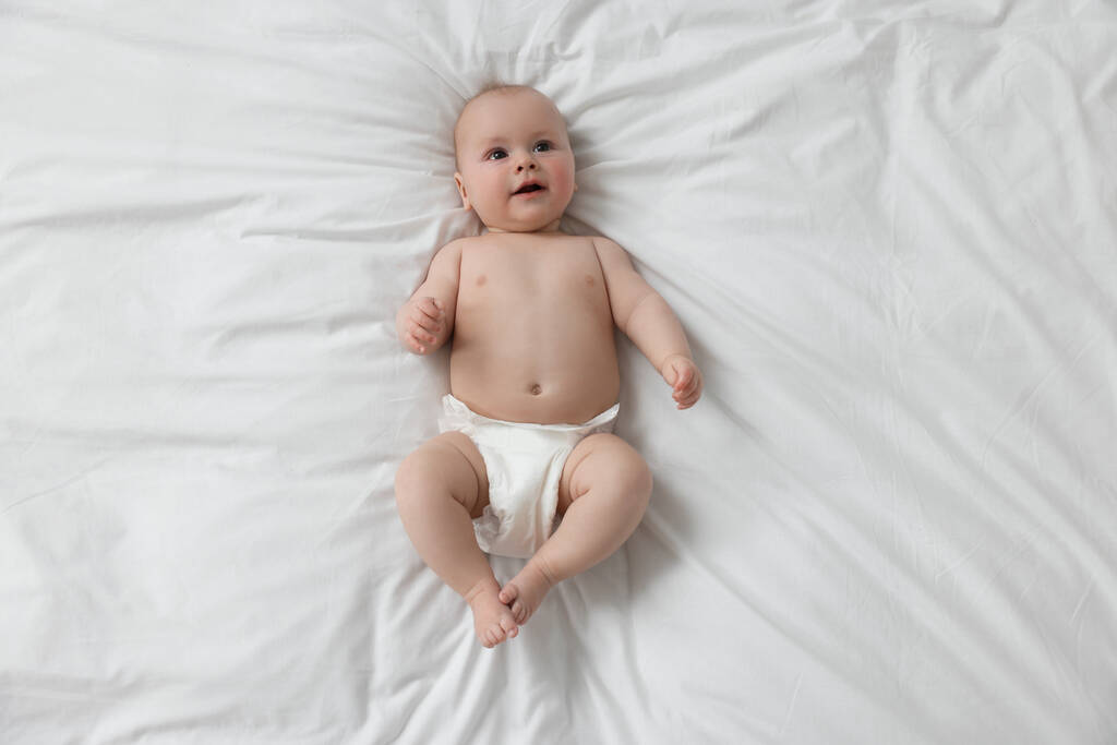 Lindo bebé en pañal acostado en la cama blanca, vista superior - Foto, Imagen