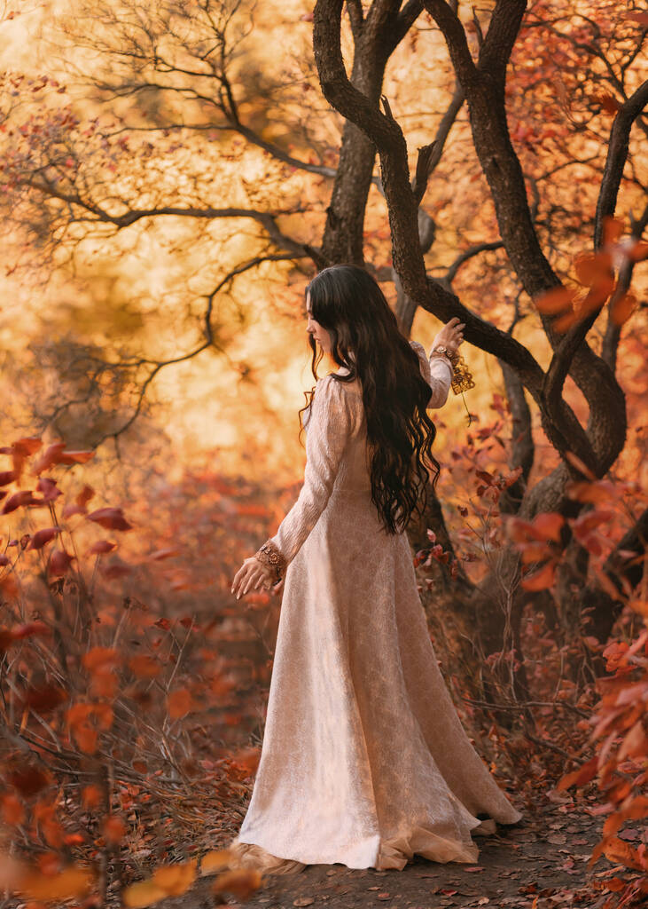 Mysterie kunst portret fantasie vrouw koningin wandelen in gotische herfst bos, witte vintage stijl jurk. Meisje prinses lang golvend brunette haar, middeleeuwse sexy dame. Rood oranje gele kleur donker boompark. - Foto, afbeelding