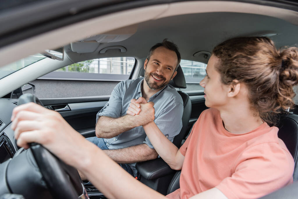 happy father and son shaking hands while sitting together in car  - Photo, Image