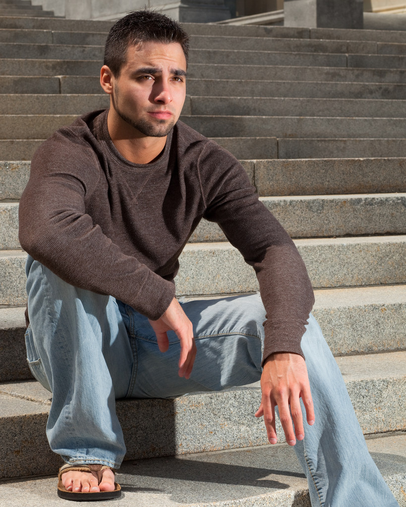 fiatal férfi ült a outsitde a nagy lépcső. - Fotó, kép