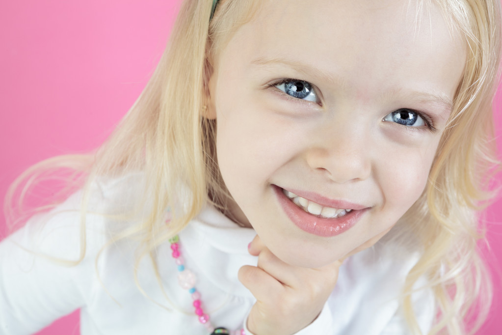 Ένα ξανθό κοριτσάκι απομονωθεί σε ροζ φόντο - Φωτογραφία, εικόνα