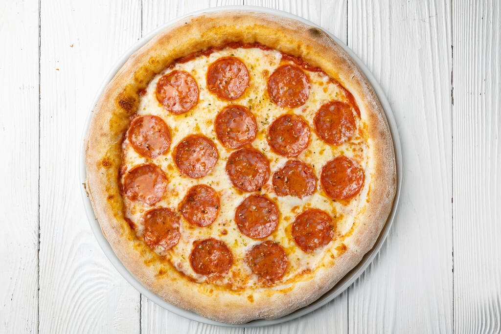 вкусная пицца на белом деревянном столе. макро - Фото, изображение