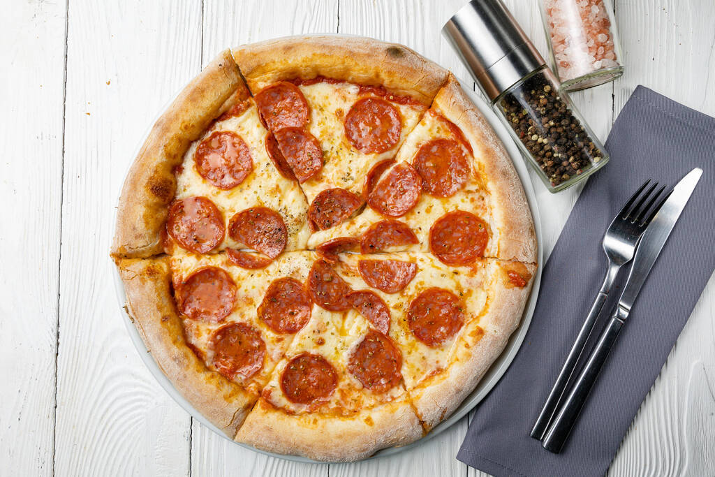 leckere Pizza auf einem weißen Holztisch. Nahaufnahme - Foto, Bild