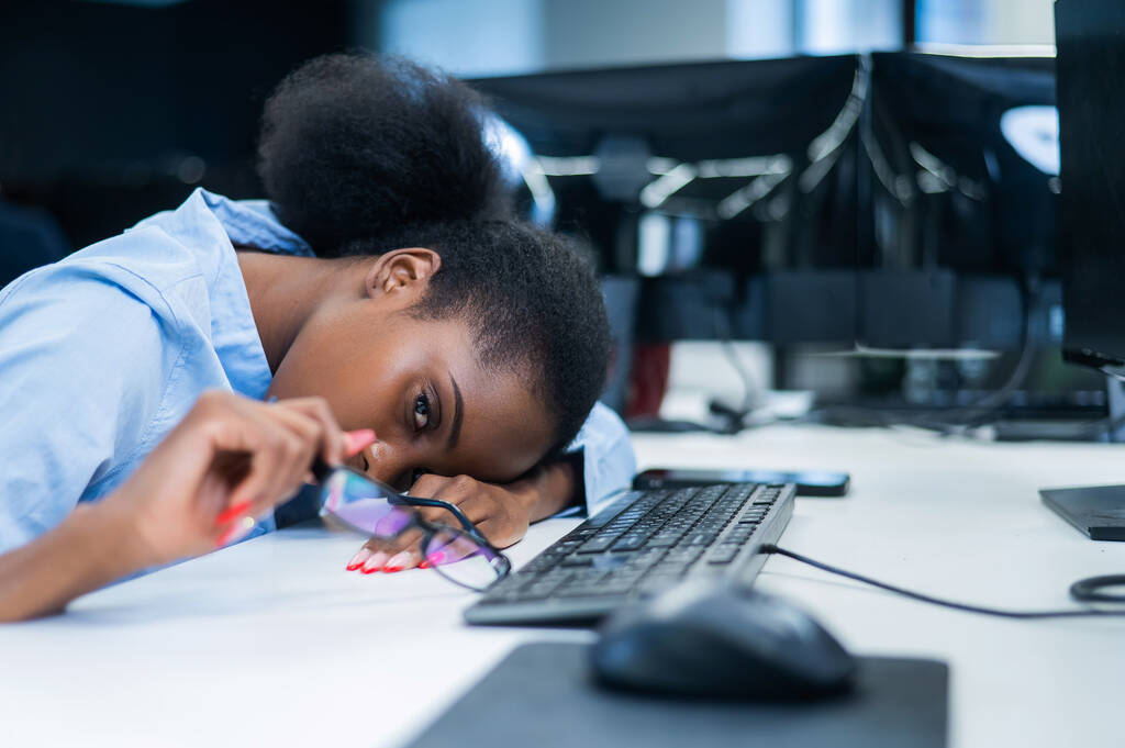 Αφρικανή νεαρή γυναίκα κοιμάται στο γραφείο εργασίας - Φωτογραφία, εικόνα
