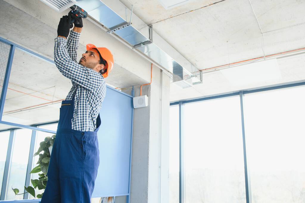 travailleur indien hvac installer un système de tuyaux canalisés pour la ventilation et la climatisation. espace de copie. - Photo, image